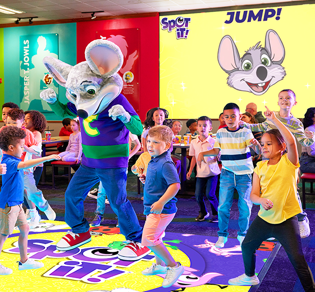 Spot&nbsp;It! tin and round cards spread out showing colorful symbols on a yellow and purple background