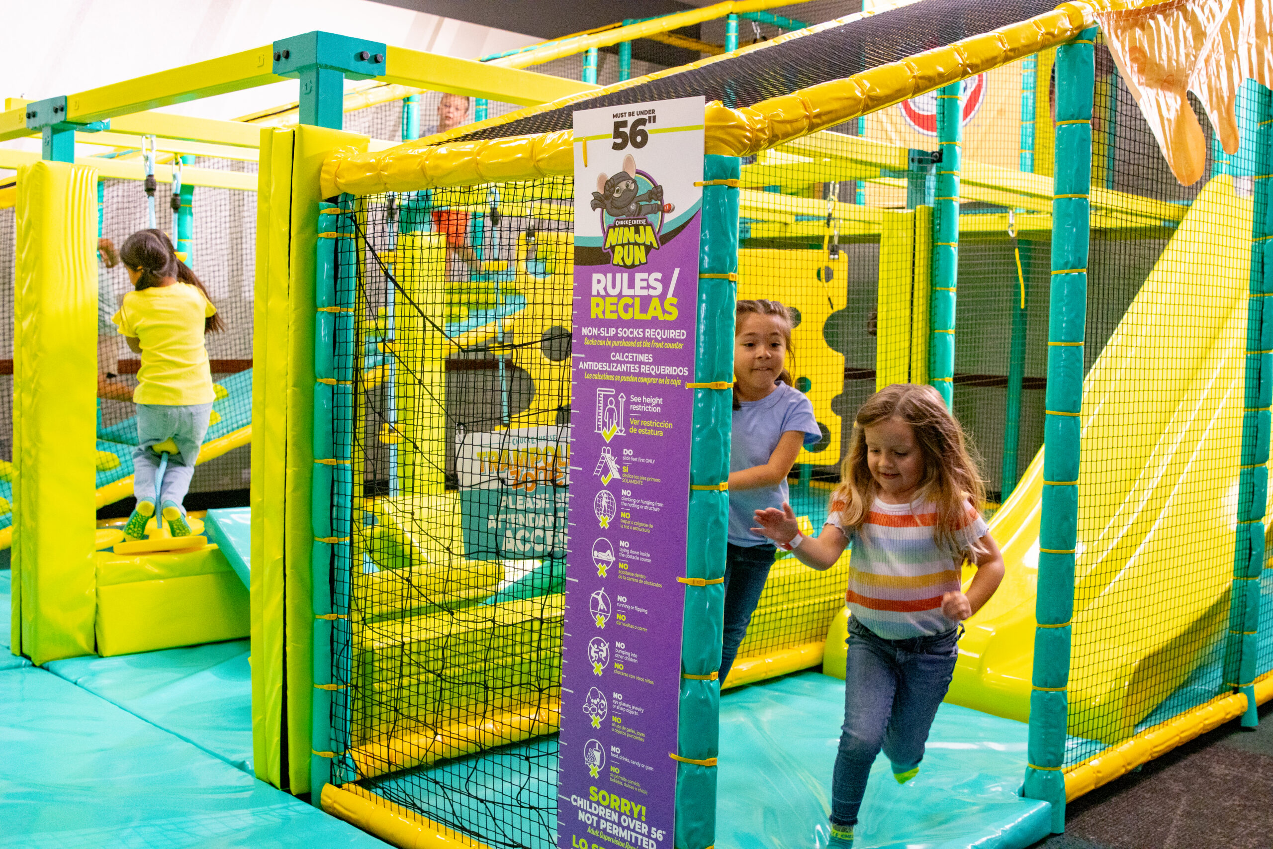 Kids playing on the colorful indoor play structure at Chuck E. Cheese Adventure World.