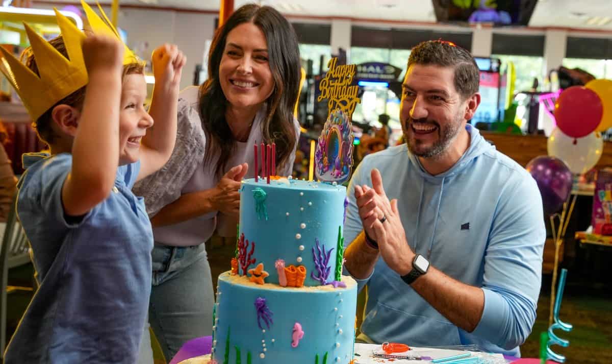 A family celebrating with a birthday cake at Chuck E. Cheese